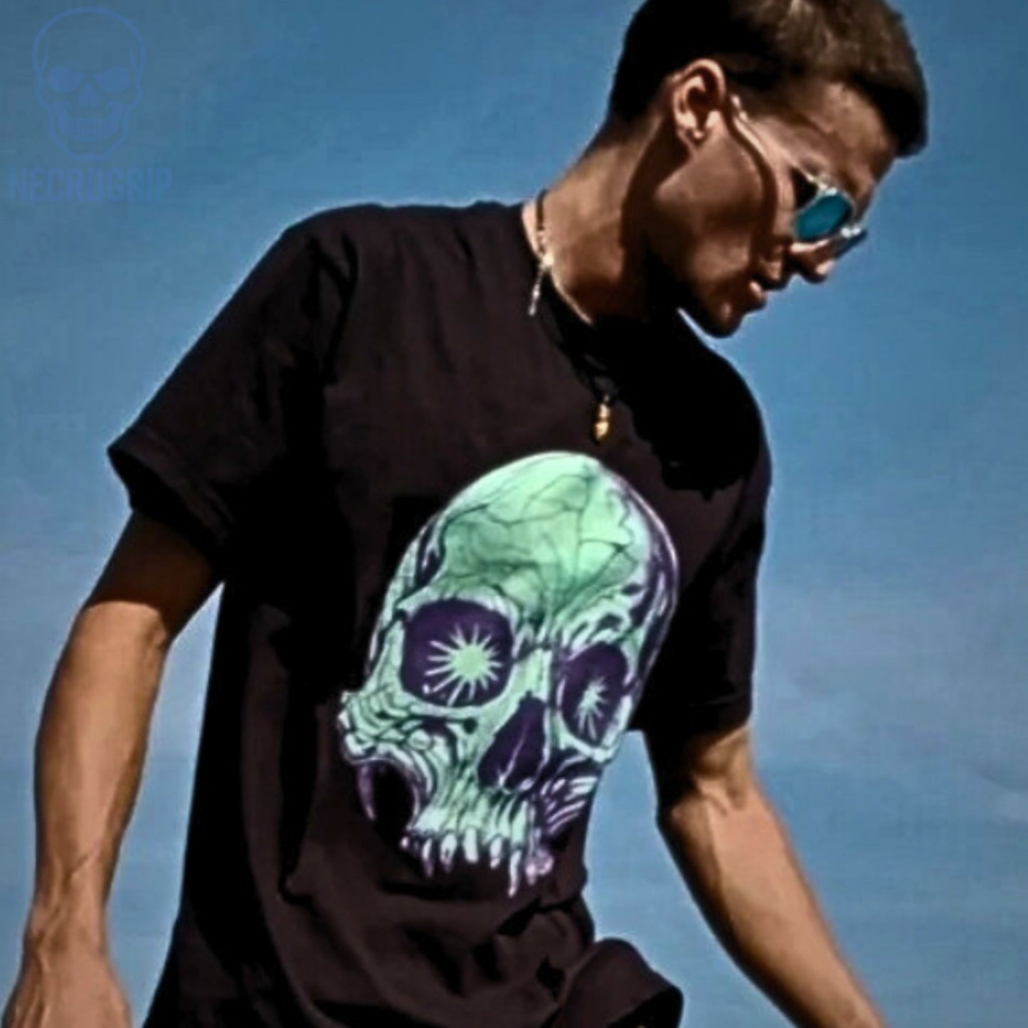 Customer wearing NecroGrip tee with glowing green skull and starburst eyes on black Comfort Colors.
