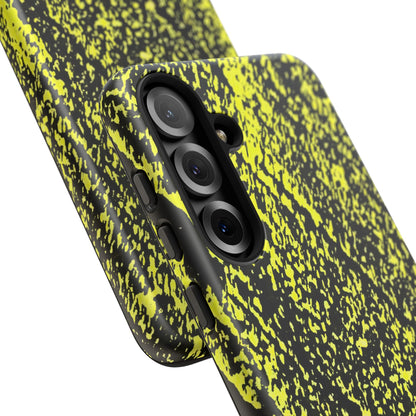 Close-up of a smartphone case with a black and neon yellow splatter pattern, fitted on a phone with a triple-camera system, shown against a plain white background.