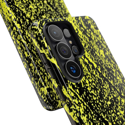 A close-up of a smartphone case with a black and neon yellow splatter pattern, shown fitted on a phone against a plain white background.