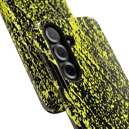 A close-up of a smartphone case with a high-contrast black and neon yellow-green splatter pattern, shown on a phone against a white background.