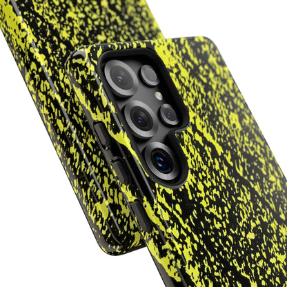 Close-up of a smartphone case with a black and neon yellow splatter pattern, fitted on a phone with a triple-camera system, shown against a plain white background.