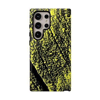 A protective phone case featuring a high-contrast black and neon yellow abstract paint splatter pattern, shown on a plain white background.