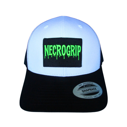 Black snapback cap with sewn NECROGRIP logo patch in neon green lettering, structured crown and mesh back.